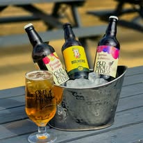 Bottled ales chilling in an ice bucket on a picnic bench in the beer garden