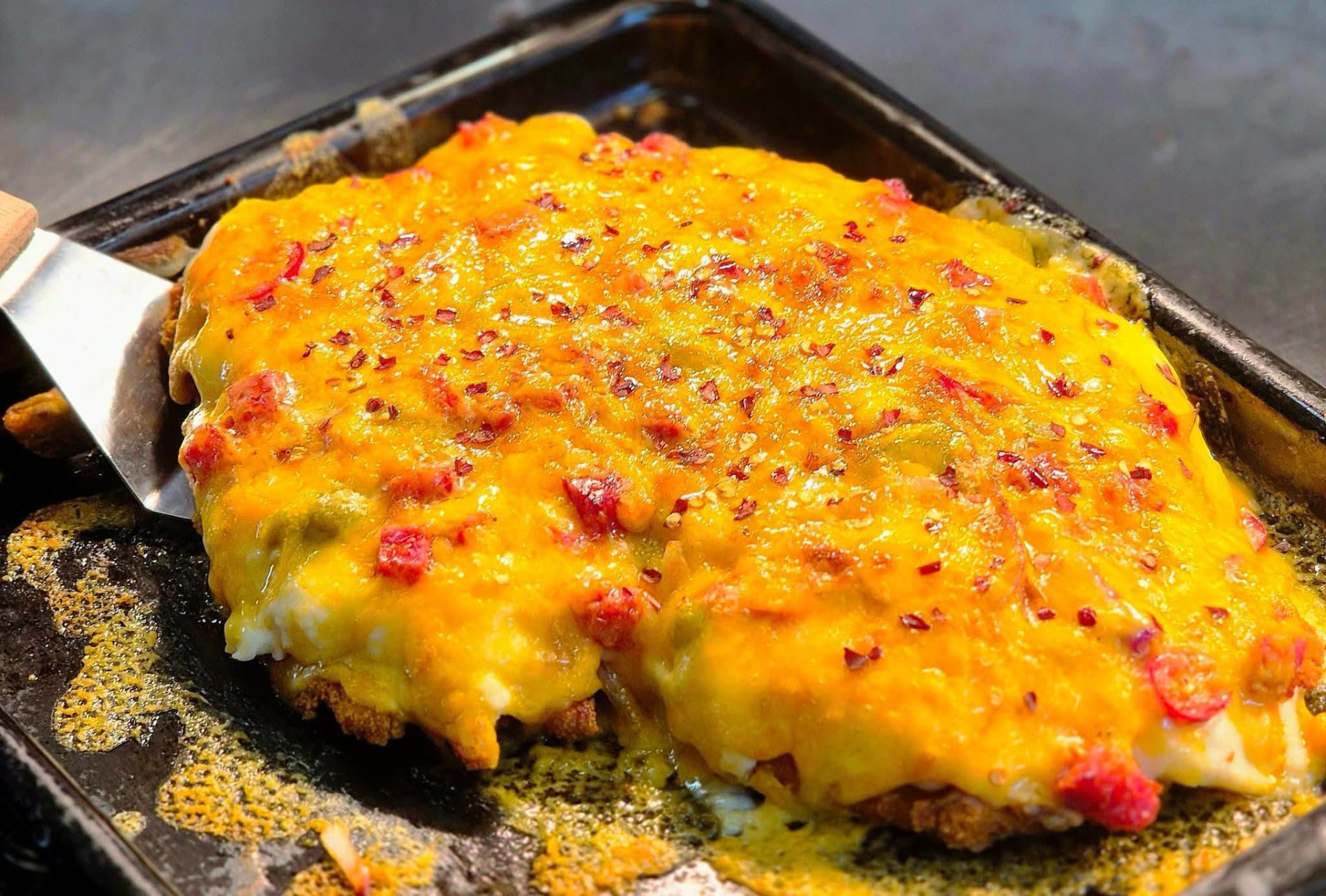 A large hotshot parmo topped with melted cheese and chilli, fresh from the oven at The Wellington Inn