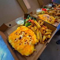 Chicken parmo served with a generous portion of chunky chips